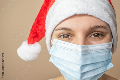 Merry Christmas. Girl in a Christmas hat and medicine mask close-up. coronavirus © robertuzhbt89