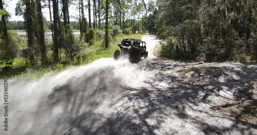 Speeding buggy on a dirt trail in a forest park photo