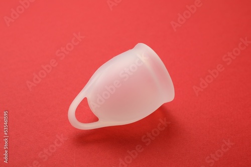 Menstrual cup on red background. Reusable female hygiene product