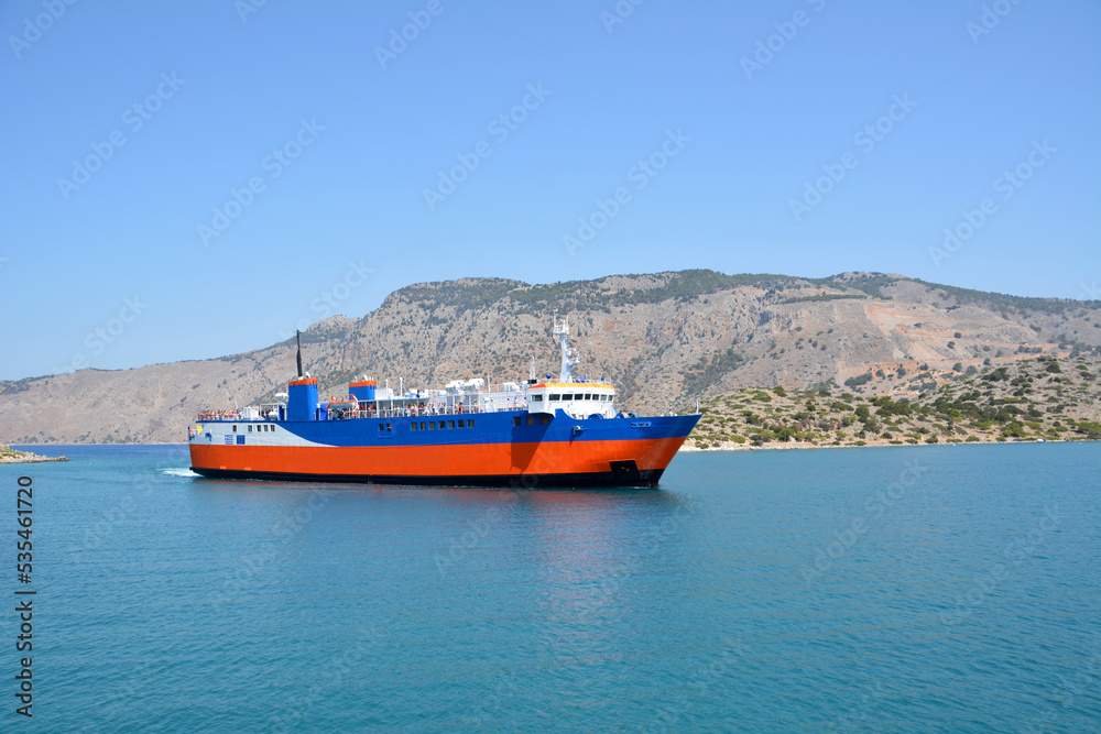 orange and blue ferryboat going on the sea with empty island on background