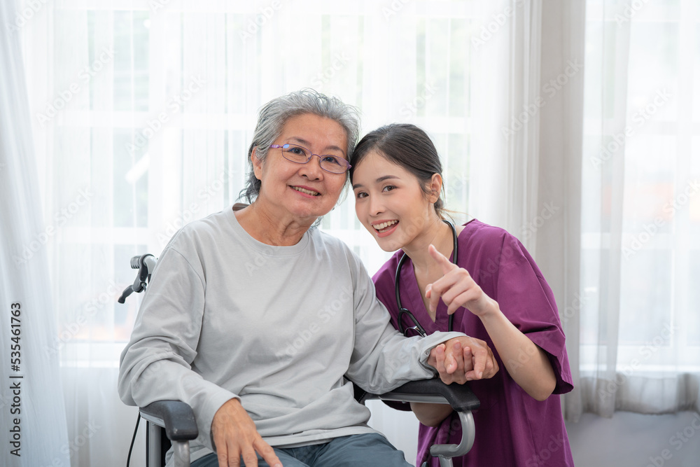 Asian young nurse taking care and talking mature female patient sitting on wheelchair in hospital. Healthcare concept. Asian young nurse taking care and talking mature female patient sitting on wheelchair in hospital. Healthcare concept.