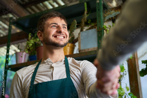 Gärtner bedankt sich mit Handschlag bei einem Kunden photo