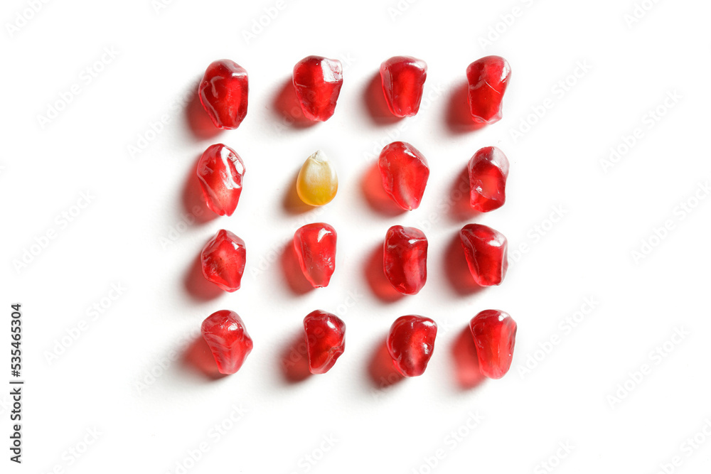 pomegranate and corn seeds isolated composition on white background