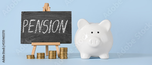 Piggy bank, money and chalkboard with word PENSION on light blue background