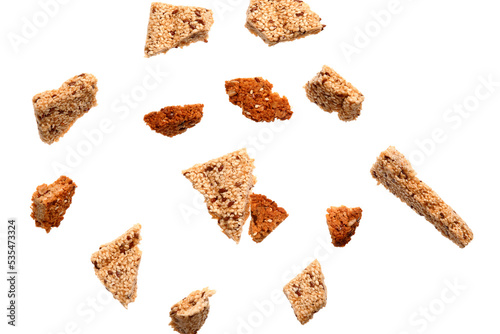 Pieces of different kozinaki with sesame seeds isolated on white background
