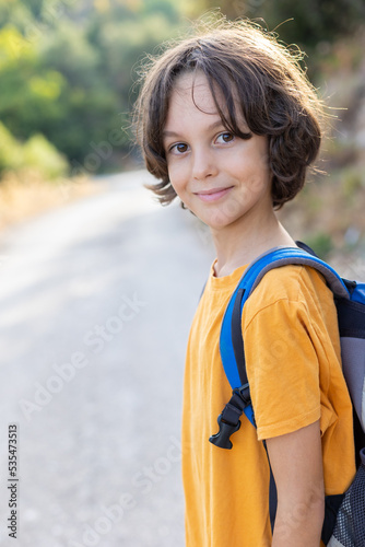 portrait of a happy little boy with a backpack. smiling boy on a hike.
