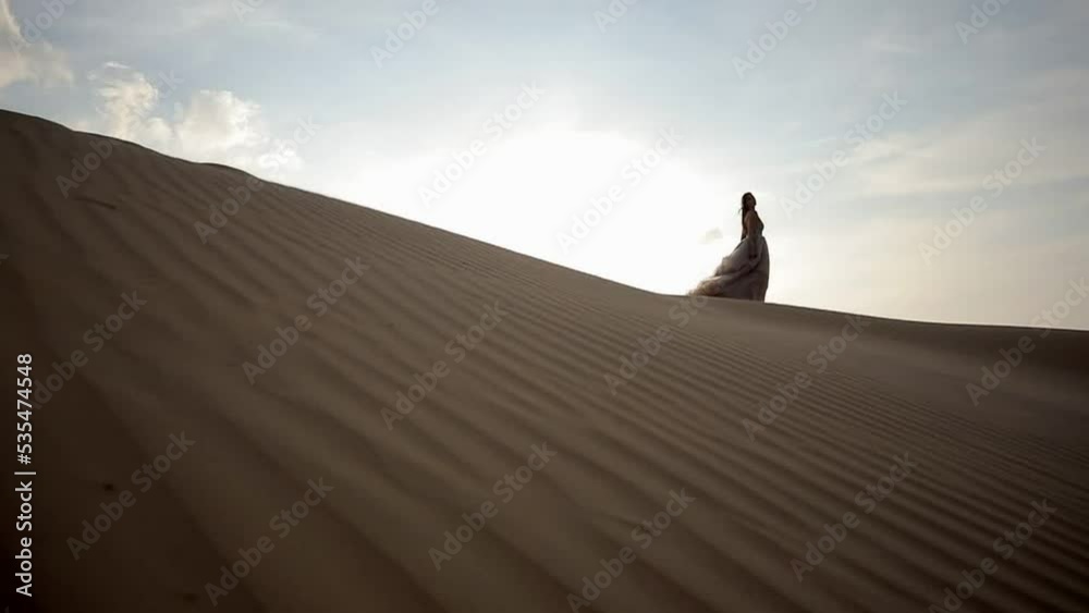 A girl in a shiny dress walks barefoot on the sand A girl in a shiny dress walks barefoot on the sand