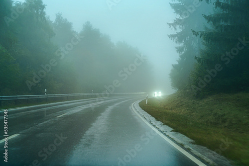 A foggy road through the forest. Fog and rain on the expressway.