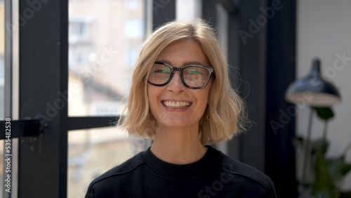 Boss woman smiling in eyeglasses, attractive blonde manager portrait on background of windows. Office room and worker in black clothes. Concept of business partner. Free Download Boss woman smiling in eyeglasses, attractive blonde manager portrait on background of windows. Office room and worker in black clothes. Concept of business partner. - GFXLoad