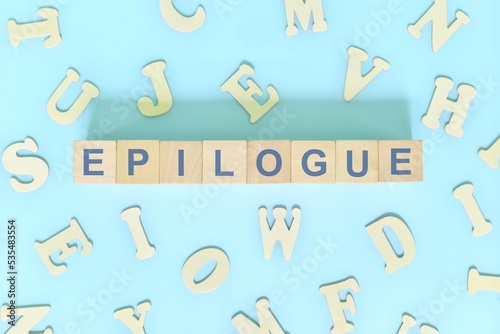 Epilogue part of a book concept. Wooden blocks typography word flat lay in blue background	 photo