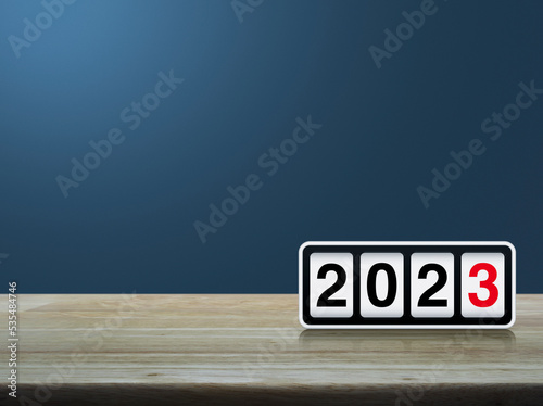 Retro flip clock with 2023 text on wooden table over light blue wall  Happy new year 2023 cover concept
