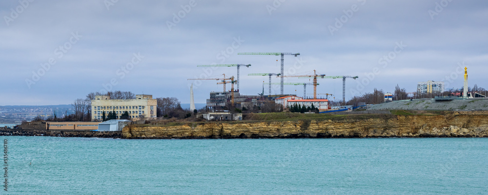Fototapeta premium Construction on the sea coast. Lots of construction cranes. Improvement and development in the Crimea. City of Sevastopol.