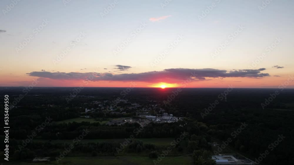 Aerial view of beautiful sunset over the houses of small town surrounded by lush greenery