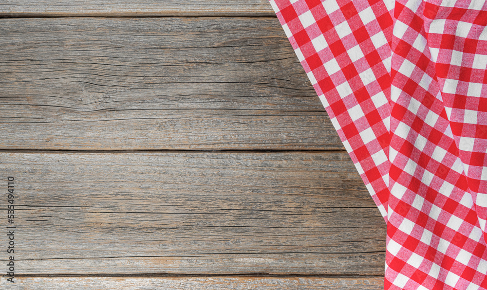 Checkered tablecloth on a wooden background. There is a place for your text. Checkered tablecloth on a wooden background. There is a place for your text.