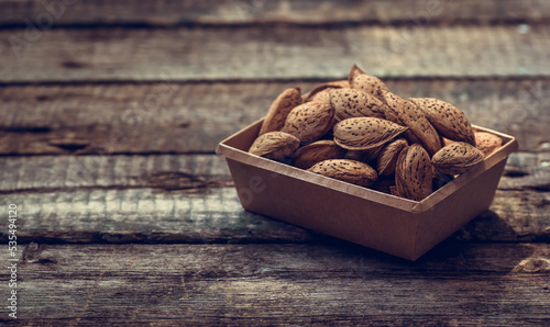 Obraz na płótnie Almonds in shell on wooden background w salonie