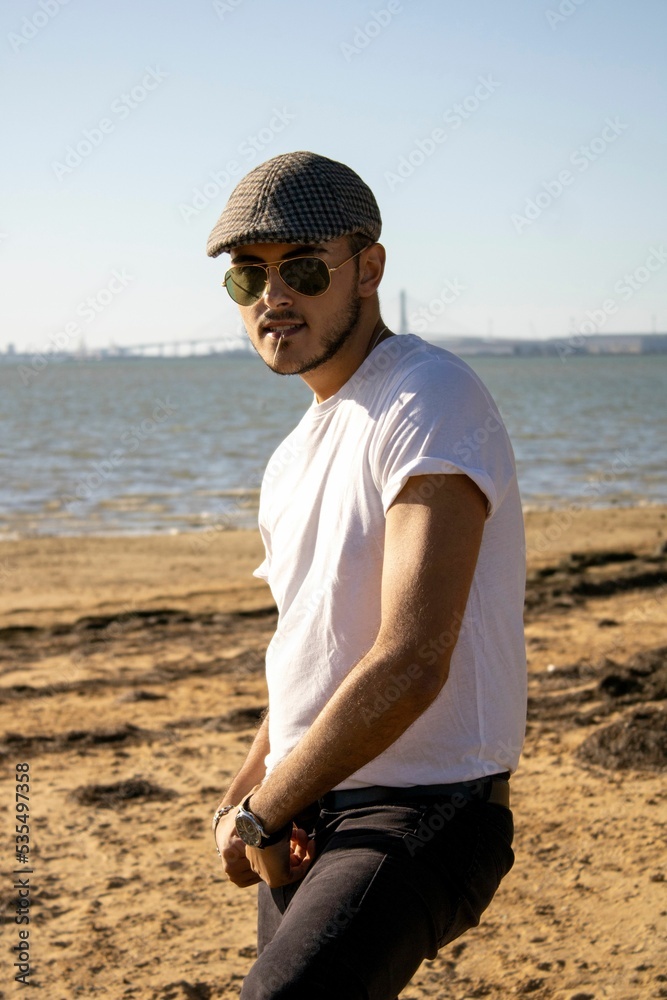 Young handsome Caucasian male with glasses and cap and toothpick in the ...