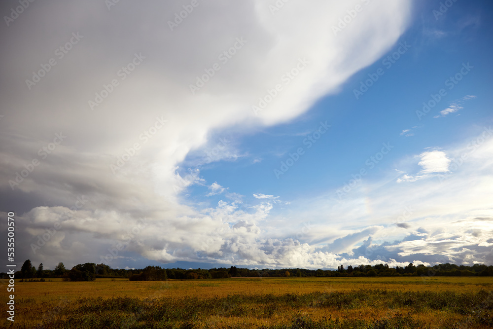 View on the road and agricultural field and beautiful sky covered with white clouds View on the road and agricultural field and beautiful sky covered with white clouds