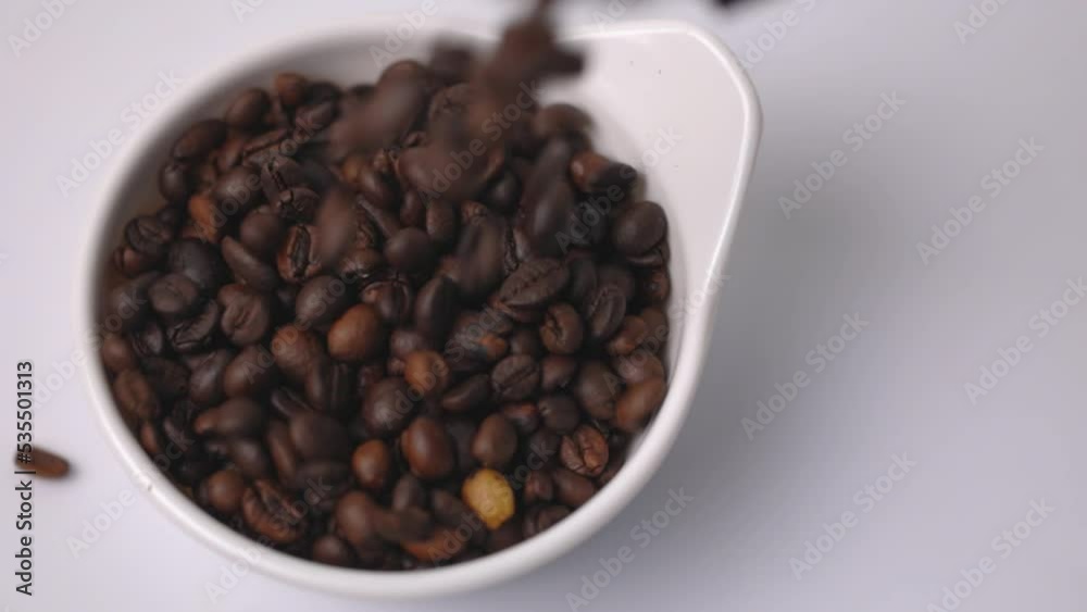 Close-up Roasted coffee beans on wooden spoon at white background. Close-up Roasted coffee beans on wooden spoon at white background.