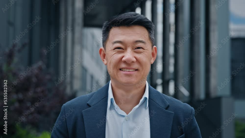 Close up front view in city outdoors Asian Korean man business boss leader company CEO smiling glad happy middle-aged businessman professional financial advisor executive leader manager male lawyer