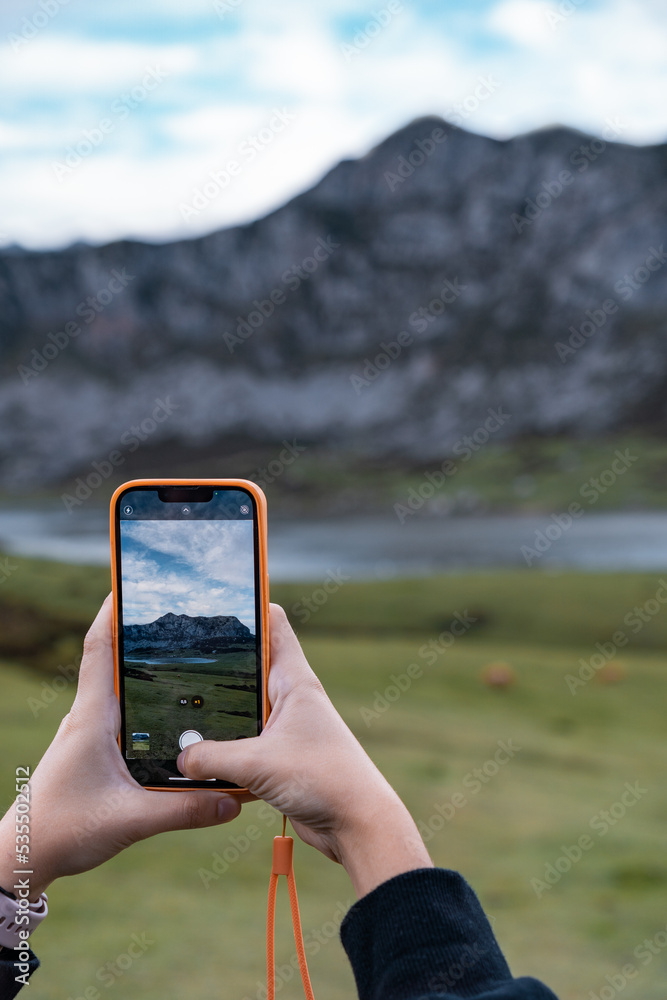 Detalle de chica joven caucásica, haciendo una fotografía con el teléfono móvil a los lagos de Covadonga. Detalle de chica joven caucásica, haciendo una fotografía con el teléfono móvil a los lagos de Covadonga.