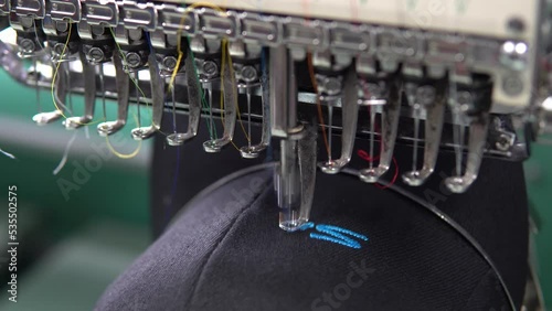 Embroidery machine in progress embroidery company logo on uniform in Textile Industry at Garment Manufacturers.