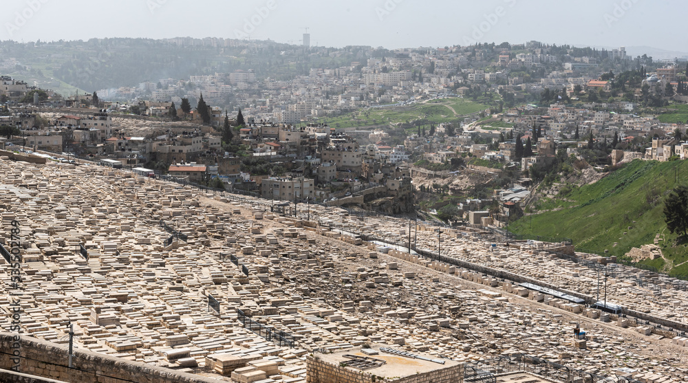 View from above over Jerusalem fortress and wall with the cemetery from Mount of Olives in foreground. Landmark landscape view of this city from Israel.