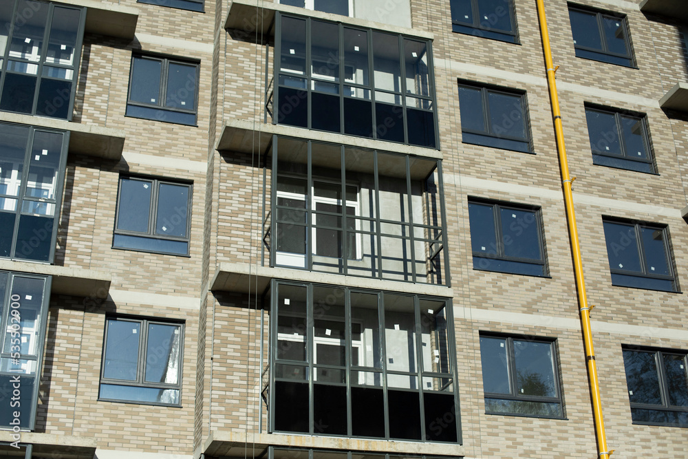 New balconies in building. New house in city. Exterior of apartment building. Wall covering.