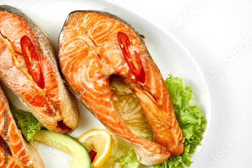 Salmon steaks in a white plate on a white background. Close-up, selective focus