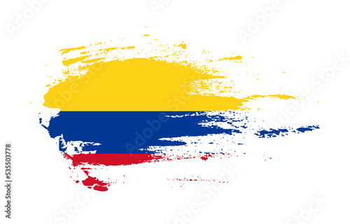 Grunge brush stroke flag of Colombia with painted brush splatter effect on solid background