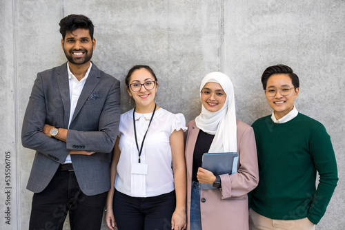 Shot of a small diverse group of businesspeople standing against a grey wall