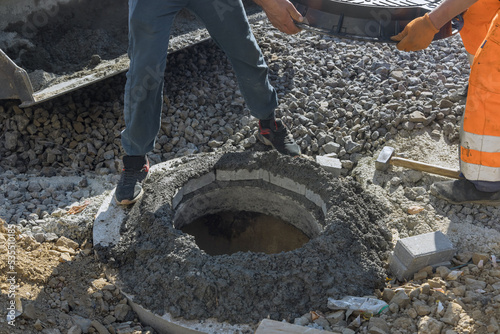 Fotografi Installation of water sewer well in ground includes cast iron sewer hatch
