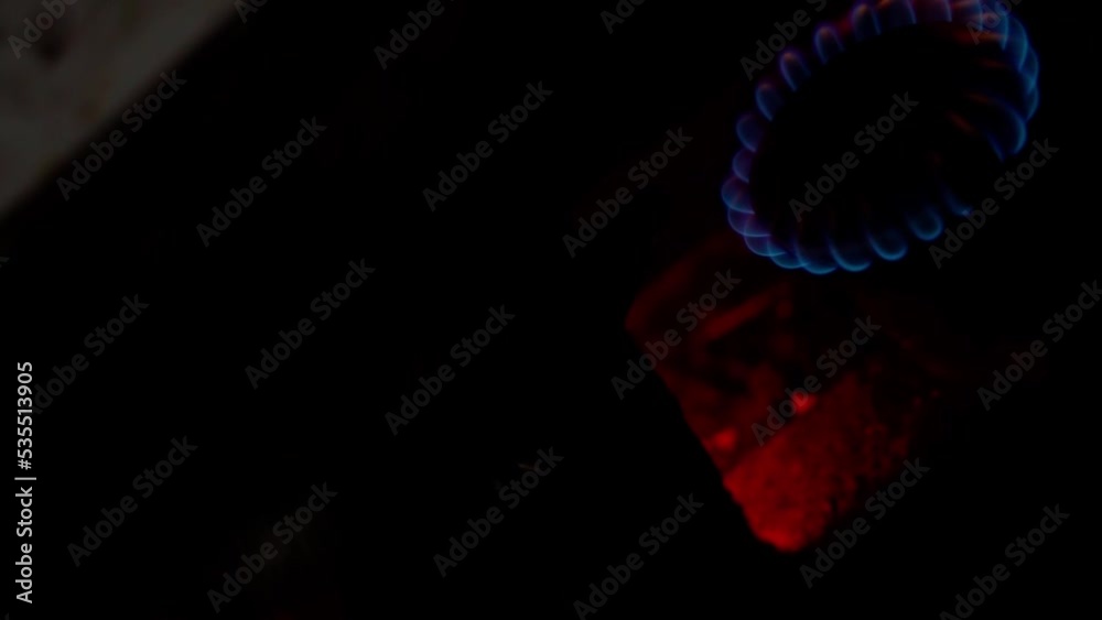 Gas burner of an old gas stove in a rural house with a burning blue flame with police alarm