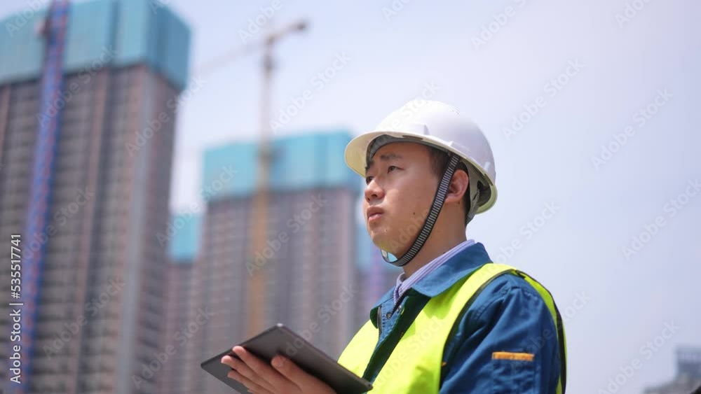 young man technician working with tablet in construction site near modern building young man technician working with tablet in construction site near modern building