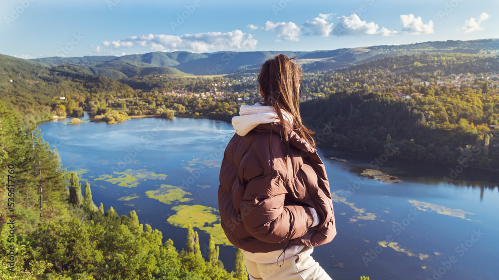 Traveler woman high above a blue lake with stunning panoramic view .Traveling in the nature in Bulgaria . Pancharevo Lake