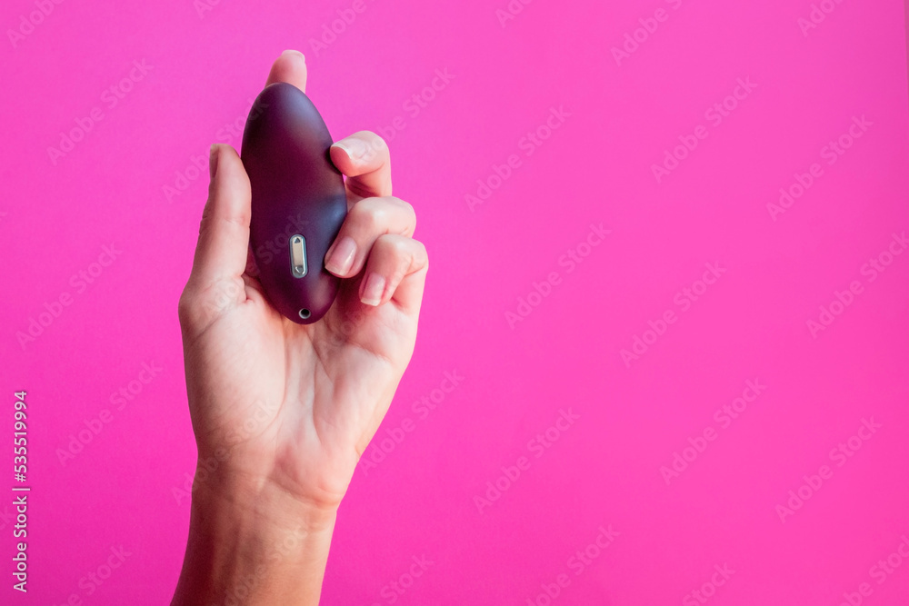 Sex toy for women, female hands holding a masturbator on the pink background. Sex toy for women, female hands holding a masturbator on the pink background.
