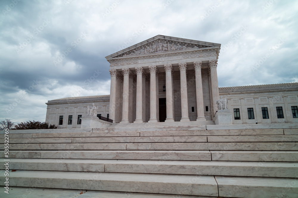 Fototapeta premium The United States Supreme Court Building in Washington, DC, is seen from the west entrance on a grey and cloudy winter day. No people are seen. Low angle wide shot.