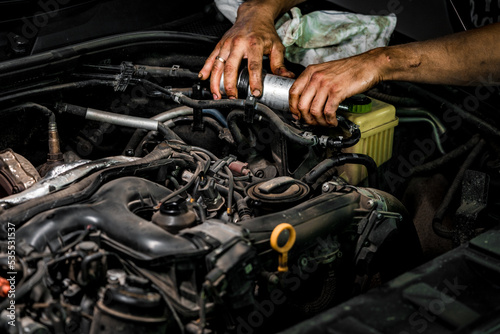 Close up of auto mechanic repairing car engine in car service