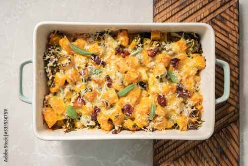 Autumn pumpkin casserole with leek, bacon, cheese and kale