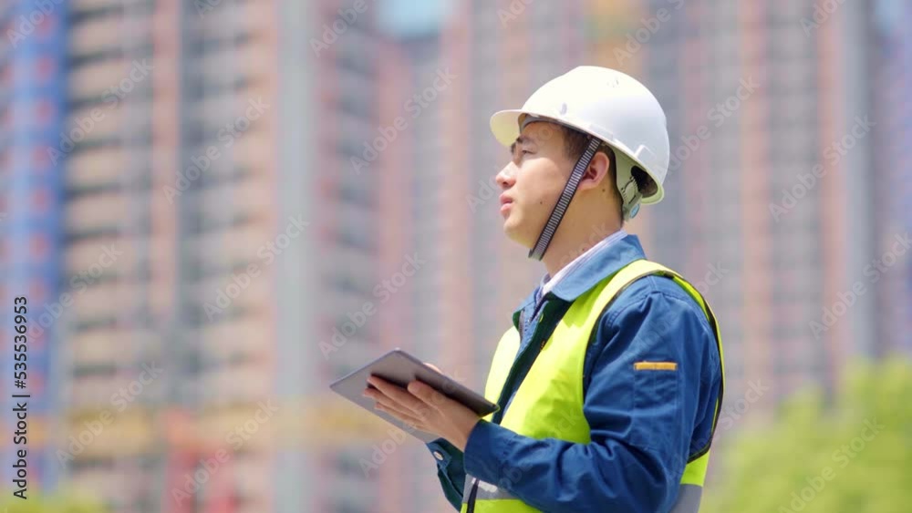 young man technician working with tablet in construction site near modern building young man technician working with tablet in construction site near modern building