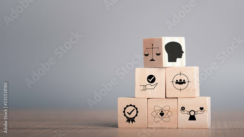 Ethics inside human mind, Business ethics concept. Ethics inside a head symbols in wooden cubes stacked on gray background with copy space.