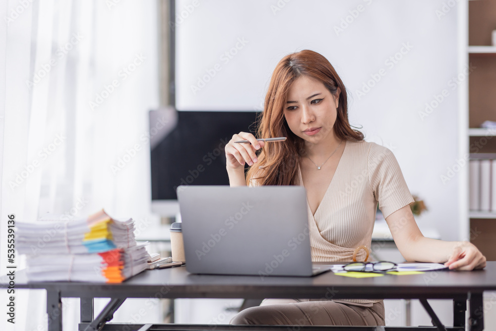 Portrait of Young Asian businesswoman is happy to work at the modern office using a laptop computer, freelance business employee online marketing e-commerce telemarketing concept.