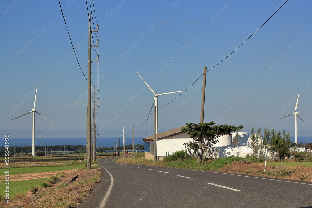 青い空と風力発電の風車、遠くには日本海