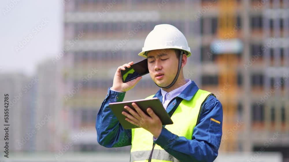 young man technician works with tablet in construction site near modern building young man technician works with tablet in construction site near modern building