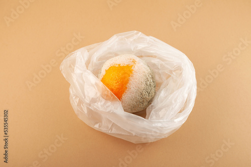 Spoiled Orange fruit in plastic bag. Concept - Improper storage of citrus fruits. Reduced organic food waste photo