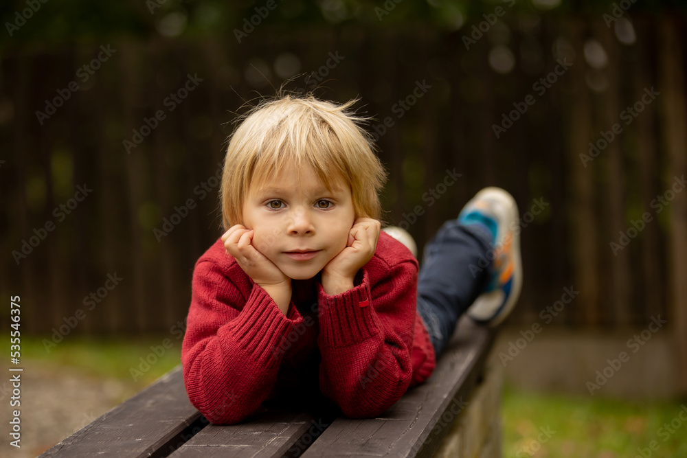 Autumn portrait of a cute blond toddler child in the park, smiling Autumn portrait of a cute blond toddler child in the park, smiling