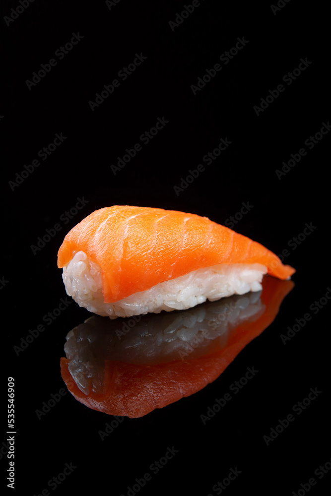 Sushi with rice and salmon on black background with reflection Sushi with rice and salmon on black background with reflection