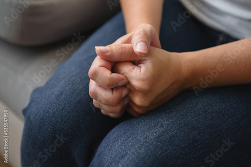 Woman's hands are clenched in nervous expectation. Symbol of depression, stress