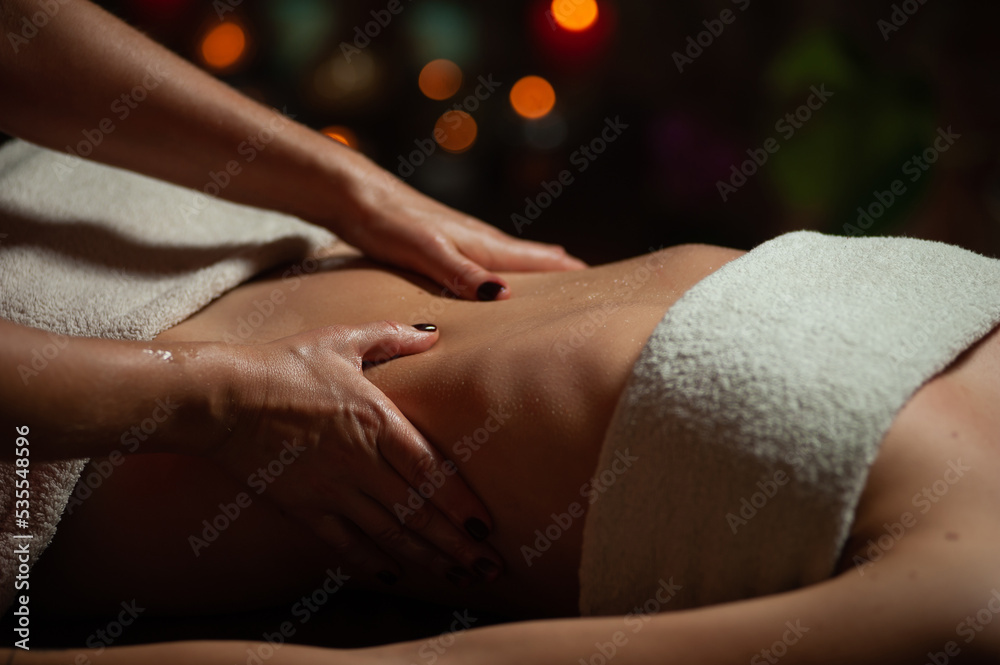 Obraz premium Professional massege woman client working at spa center. Young beautiful woman relaxing during full body massage at luxury resort wellness wellbeing pampering skin