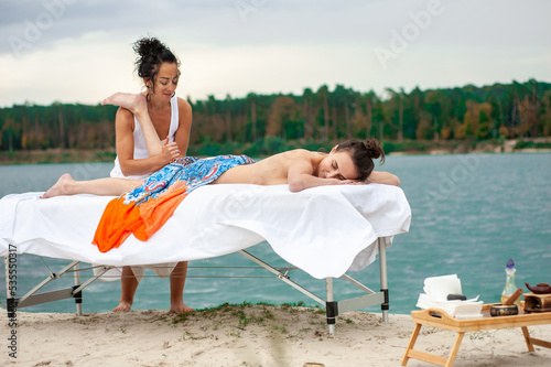 An attractive caucasian woman lying down on a massage bed at a spa