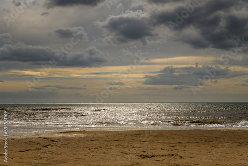An autumnal HDR seacape image of Fleetwood beach with calm seas, hazy sun and solitude, Lancashire, England.